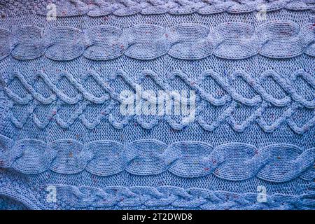 Schöne Textur eines weichen, warmen natürlichen Pullovers mit einem Strickmuster aus Fäden. Der Hintergrund. Stockfoto