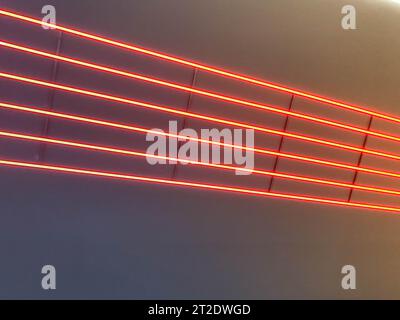Textur von rot leuchtenden hellen Neon-LED-mehrfarbigen abstrakten Laserstreifen und Linien von parallelen Lampen. Der Hintergrund. Stockfoto