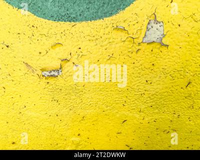 Bulk Lack auf einem Stück Metall. Helle Textur. Gelber und grüner Kreis. Abblätternde Farbe, gerissenes Material. Farbe und Metallhintergrund. Stockfoto