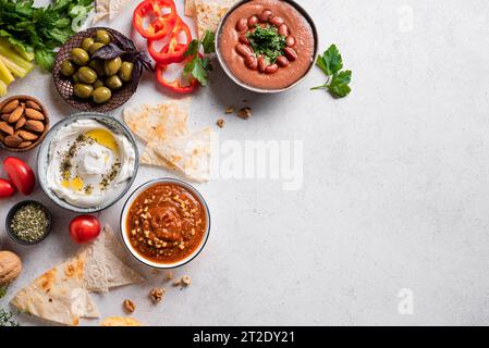 Auswahl an arabischen Mezze-Speisen - faul, Labneh-Joghurt, Muhamara-Dip auf weißem Hintergrund, Blick von oben, Kopierraum. Nahöstliche Küche. Stockfoto