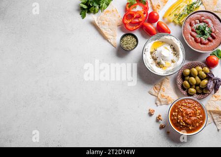 Nahöstliches, traditionelles arabisches Frühstück mit Labneh-Frischkäse, Foul, Muhammara-Dip und Zaatar, Blick von oben, Kopierraum. Mezze-Dip-Set, Gemüse Stockfoto