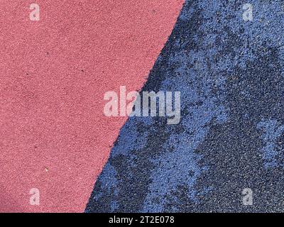Blaue und rosafarbene Gummioberfläche antitraumatische Sicherheitsfliese für Workout Sportspielplatz im öffentlichen Park oder Innenhof. Der Hintergrund. Textur. Stockfoto