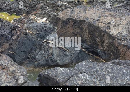 Spektakuläre Schluchten, Bögen und Seestapel prägen die Küste zwischen Kintra und Port Alsaig auf Islay. Stockfoto