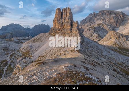 Sonnenuntergang mit pastellfarbenem Himmel am Toblin-Turm in den italienischen Dolomiten. Einsamer Felsenmonolith, freistehender butte umgeben von imposanten Berggipfeln Stockfoto