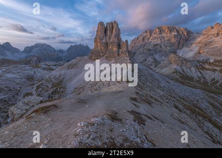 Sonnenuntergang mit pastellfarbenem Himmel am Toblin-Turm in den italienischen Dolomiten. Einsamer Felsenmonolith, freistehender butte umgeben von imposanten Berggipfeln Stockfoto