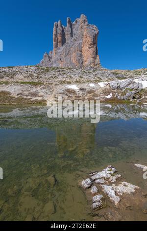 Ostwand der 3 Cime di Lavaredo im Herzen der italienischen Dolomiten. Erodierter Kalkstein reflektiert im noch alpinen Teich Stockfoto