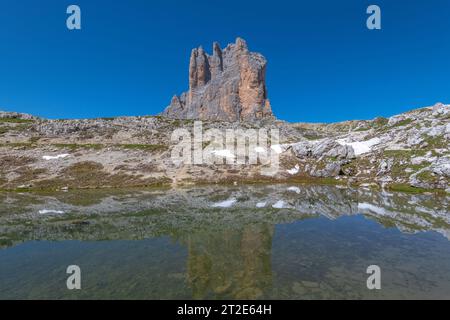 Ostwand der 3 Cime di Lavaredo im Herzen der italienischen Dolomiten. Erodierter Kalkstein reflektiert im noch alpinen Teich Stockfoto