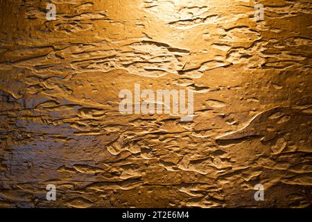 Die braune Textur der Betonwand besteht aus dekorativem Putz mit Flecken, Flecken und Schatten. Der Hintergrund. Stockfoto