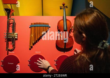 London, Großbritannien. 19. Oktober 2023. Ein Mitarbeiter interagiert mit Musikinstrumenten, bei denen jede Platte den Klang jedes einzelnen Instruments abspielt, bei einer Vorschau von „Turn IT Up: The Power of Music“, einer interaktiven Ausstellung im Wissenschaftsmuseum, die untersucht, wie Musik unser Leben prägt. Die Ausstellung findet vom 19. Oktober bis 6. Mai 2024 statt. Quelle: Stephen Chung / Alamy Live News Stockfoto