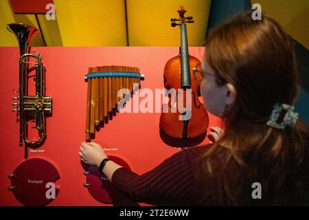 London, Großbritannien. 19. Oktober 2023. Ein Mitarbeiter interagiert mit Musikinstrumenten, bei denen jede Platte den Klang jedes einzelnen Instruments abspielt, bei einer Vorschau von „Turn IT Up: The Power of Music“, einer interaktiven Ausstellung im Wissenschaftsmuseum, die untersucht, wie Musik unser Leben prägt. Die Ausstellung findet vom 19. Oktober bis 6. Mai 2024 statt. Quelle: Stephen Chung / Alamy Live News Stockfoto