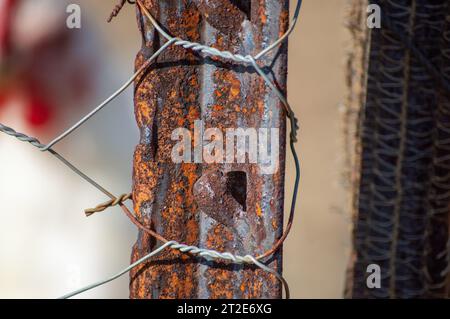 Ein alter Zaunpfahl, der für einen Hühnerstall benutzt wird. Der Zaunmast zeigt die Auswirkungen von Witterung und Verfall auf ländliche Strukturen Stockfoto