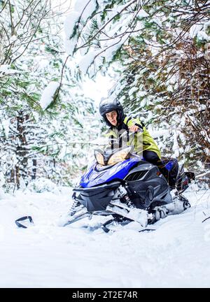 Sportler fährt ein Schneemobil in den Bergen. Schneemobil im Schnee. Konzept Wintersport. Der Mensch fährt Schneemobil in den Bergen. Pilot auf einer Sportart Stockfoto