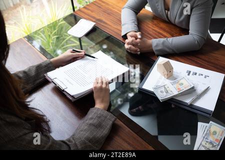 Immobilienmakler, der einen Baudarlehensvertrag vorlegt und genehmigt. Immobilieninvestition, Hypothekenkonzept. Stockfoto