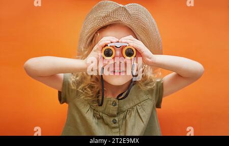 Junge glückliche Frau tragen Sommer-Freizeitkleidung halten in der Hand Karte verwenden Fernglas isoliert auf glattem gelbem Hintergrund. Reisen ins Ausland kostenlos Stockfoto