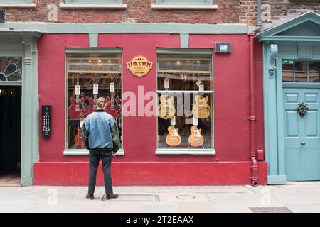 Ein junger Mann in einer Jeansjacke, der bei No. Shoppt Tom Guitars, Denmark Street, London, WC2, England, GROSSBRITANNIEN Stockfoto