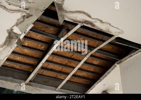 Deckenpaneele hatten ein großes Loch im Dach durch ein Regenwasserleck beschädigt. Die Decke wurde durch Wasser beschädigt. Die Decke brach zusammen Stockfoto