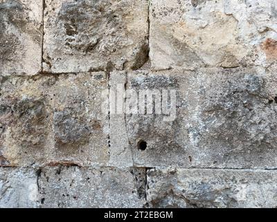 Ein Fragment einer Steinmauer aus grob gehauenem Stein. Stockfoto