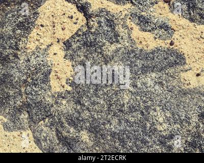 Natürliche Textur. Mehrfarbiger Stein. Grau-rosa Zeichnung auf Naturmaterial. Bergwelt. Sand auf Stein, natürliches Bild. Stockfoto