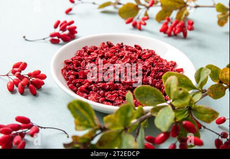 Haufen getrockneter Berberis vulgaris, auch bekannt als gewöhnliche Berberitze, Europäische Berberitze oder Berberitze auf Teller in der Küche. Essbare pflanzliche Medizin. Stockfoto