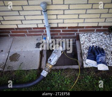 Bad Brahmstedt, Deutschland. Oktober 2023. Ein Schlauch mit Düse ist an einem Einfüllstutzen befestigt, um dem Kunden in einem Einfamilienhaus Heizöl zu liefern. Quelle: Christian Charisius/dpa/Alamy Live News Stockfoto