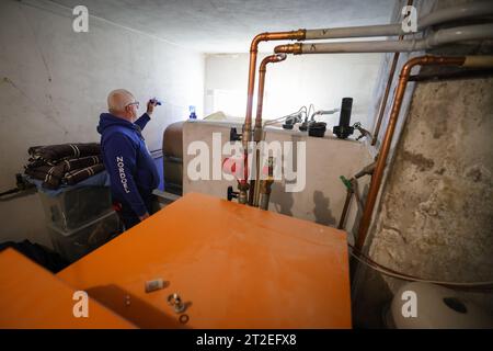 Bad Brahmstedt, Deutschland. Oktober 2023. Ein Mitarbeiter eines Diesel- und Heizölunternehmens überprüft den Füllstand in den Tanks, wenn Heizöl an einen Kunden in einem Einfamilienhaus geliefert wird. Quelle: Christian Charisius/dpa/Alamy Live News Stockfoto