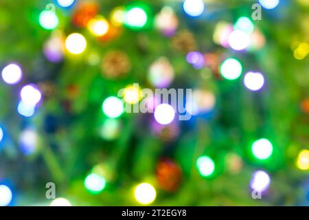 Bokeh beleuchtet den Hintergrund. Abstraktes, mehrfarbiges Licht. Verschwommenes Licht auf dem Weihnachtsbaum, weihnachtlicher Hintergrund Stockfoto