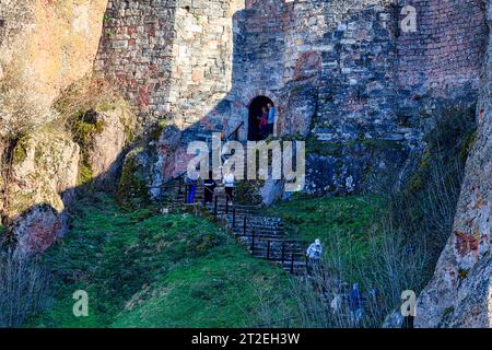 Gruppe von aktiven Senioren Wandern und Klettern auf den Stufen, die zu beeindruckenden Felsformationen führen, Belogradchik Festung, Kaleto, Bulgarien Stockfoto