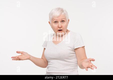 Ältere ältere kaukasische Frau, die schockiertes und verwirrtes Gefühl mit geöffneter Hand ausdrückt, Studio-Aufnahme in weißem isolierten Hintergrund Stockfoto