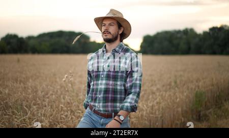 Positiver kaukasischer, gut aussehender Mann mit Bart, der in die Kamera lächelt und im Stehen steht Stockfoto