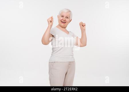 Porträt einer gesunden aktiven älteren älteren Frau lächelnd mit Händen heben in isoliertem weißen Hintergrund Studio-Aufnahme, glückliches Rentenkonzept Stockfoto