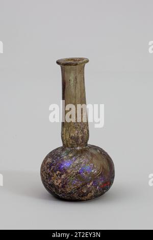 Glasparfümflasche Roman Ende 1.–3. Jahrhundert CE durchscheinend blassblau-grün, stark gestreift mit Mangan-Lila.umgestreifter Rand, umgeklappt, auf der Oberseite flachgelegt; hoher zylindrischer Hals, nach unten ausdehnend, dann um die Basis herum bestückt; kugelförmiger Körper hocken; Boden leicht eingedrückt.gebrochen und um den Hals repariert; Nadelstich- und langgezogene Blasen; tiefe Lochfraß und Verwitterung mit etwas schillernder Wirkung. Mehr anzeigen. Parfümflasche aus Glas. Roman. Ende 1.–3. Jahrhundert n. Chr. Glas; geblasen. Mitte Imperial. Glas Stockfoto