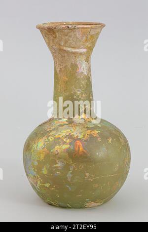 Glasflasche römisch 4.–5. Jahrhundert CE durchscheinend blau grün. Ausgeklappter, über- und eingeklappter und in den breiten und tiefen, konischen Mund gepresster Rand; zylindrischer Hals, leicht nach unten ausdehnbar, mit Werkzeugsspuren um die Basis; großer, kugelförmiger Hockkörper; eingeschobener Boden, flach bei center.Complete; aber gebrochen und restauriert um den Rand und den Mund; wenige Nadelstichbläschen; tiefe Lochstellen mit abgestumpften, brillant schillernden und dicken, cremigen Witterungseinflüssen. es gibt einen schräg verlaufenden Kamm an der Seite des Mundes und zwei große Einbuchtungen an der Seite des Oberkörpers. Mehr anzeigen. Glasflasche. Rom Stockfoto