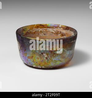 Glasschale römisch Ende des 1. Jahrhunderts v. Chr. bis Anfang des 1. Jahrhunderts CE durchscheinendes Honigbraun abgerundeter vertikaler Rand; leicht konkave Seiten, sich nach unten verjüngend; flacher Boden. Horizontale Rillen im Inneren; einzelne dickere Rillen 0,8 cm unter Rand, Band mit zwei dünneren Rillen 2,2 cm unter rim.Complete, außer für kleines seitliches Loch; gebrochen und repariert mit zwei großen Rissen, die von den Seiten des Feldes nach unten verlaufen; Nadelblasen; tiefe Lochfraß, stumpfende und schillernde Witterung außen; cremige Witterungseinflüsse bedecken den größten Teil des Innenraums. Stockfoto