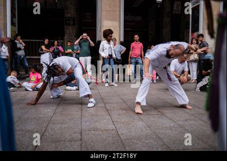 Mitglieder von Mestre Branco Capoeira Escola demonstrieren auf der Straße während der Feste von El Pilar in Saragossa, Aragonien, Spanien Stockfoto