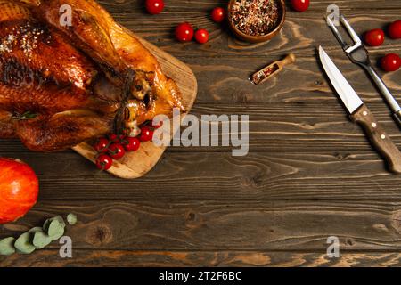 thanksgiving-Essenszusammensetzung, gebratener truthahn mit Gewürzen und roten Kirschtomaten auf Holztisch Stockfoto