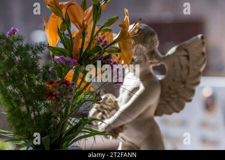 Engelsfigur, Putto und Blumenstrauß auf einem Grab auf einem Friedhof in Sardinien, Bari Sardo, Ogliastra, Sardinien, italien Stockfoto