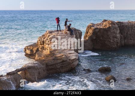 Alexandria, Ägypten - 13. Dezember 2018: Die Jungs sind an einem stürmischen Tag an den Ruinen der Steinmauern der Küste Stockfoto