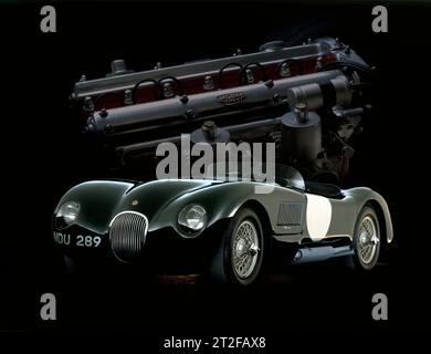 1953 Jaguar C-TYPE NDU 289 in British Racing Green und White Roundels, mit XK-Motor im Hintergrund. Studio-Illustration für einen Kalender. Stockfoto