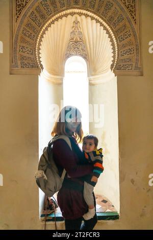 Eine junge Frau mit ihrem Sohn besucht den Innenhof mit Springbrunnen in der Alcazaba in Malaga, Andalusien. Spanien. Mittelalterliche Festung Stockfoto