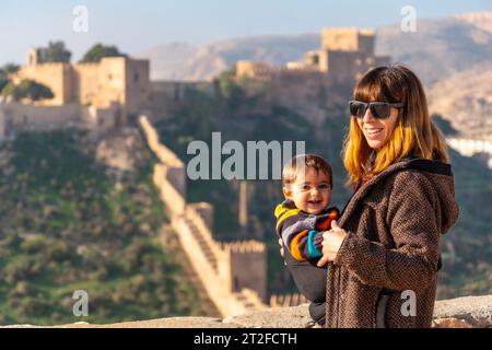 Eine junge Mutter mit ihrem Baby am Aussichtspunkt des Cerro San Cristobal de la Muralla de Jairan und der Alcazaba in der Stadt Almeria, Andalusien. Stockfoto