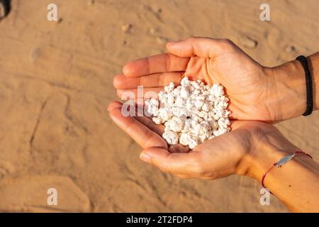 Eine junge Frau mit Steinen in der Hand am Popcorn Beach in der Nähe der Stadt Corralejo, nördlich der Insel Fuerteventura auf den Kanarischen Inseln. Spanien Stockfoto