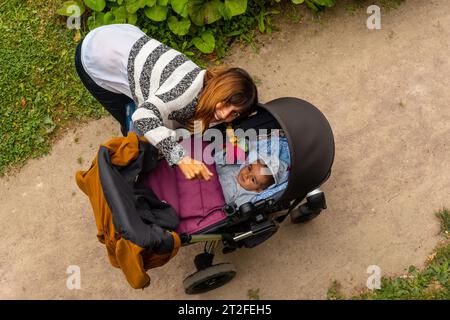 Eine Mutter mit ihrem Baby in den Gärten der Abbaye de Beauport im Dorf Paimpol im Departement Cotes-d'Armor in der französischen Bretagne. Frankreich Stockfoto