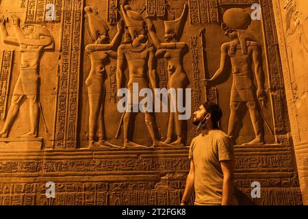 Ein junger Mann besucht den wunderschönen Tempel von KOM Ombo bei Nacht, den Tempel, der den Göttern Sobek und Horus gewidmet ist. In der Stadt KOM Ombo bei Aswer Stockfoto