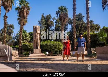 Ein Touristenpaar, das die Skulptur des Pharao Ramses II. In Memphis in Kairo, Ägypten, besucht. Alte Stadt, in der der Gott Ptah verehrt wurde Stockfoto