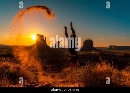 Ein brünettes Lifestyle-Mädchen am Morgen des Monument Valley, das mit dem Sand spielt, Utah Stockfoto