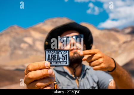 Ein junger Mann mit einem Patch für Area 51 Kleidung auf dem Artist's Drive in Death Valley, Kalifornien. Usa Stockfoto