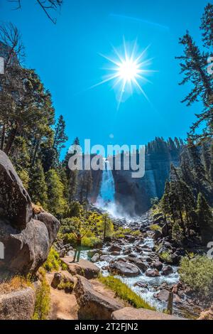 Ein brünette Tourist mit schwarzem T-Shirt in Vernal Falls von unten mit Blick auf den Wasserfall. Kalifornien, Usa Stockfoto