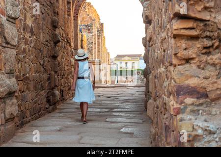 Römische Ruinen von Merida, eine junge Touristin in einem weißen Kleid, die das römische Theater und Amphitheater besucht Stockfoto