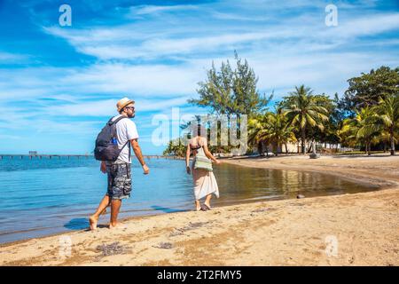 Zwei junge Leute laufen am Strand von Sandy Bay auf Roatan Island entlang. Honduras Stockfoto