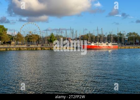 Die rote Fähre nach l'île de Ré im Abendlicht in der wunderschönen Küstenstadt La Rochelle an der Westküste Frankreichs mit Yachten und Fischerbooten. Stockfoto